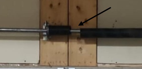 Visible gap between the coils of a broken garage door torsion spring